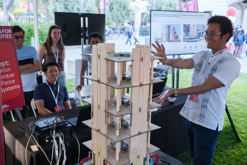 Gustavo A. Araújo R. presenting a scaled mass timber rocking-wall model at the Stanford Engineering Centennial Showcase
